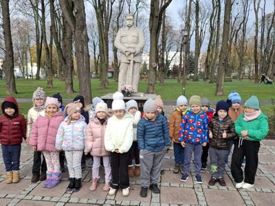 Grupa przedszkolna na tle pomnika Józefa Piłsudzkiego.