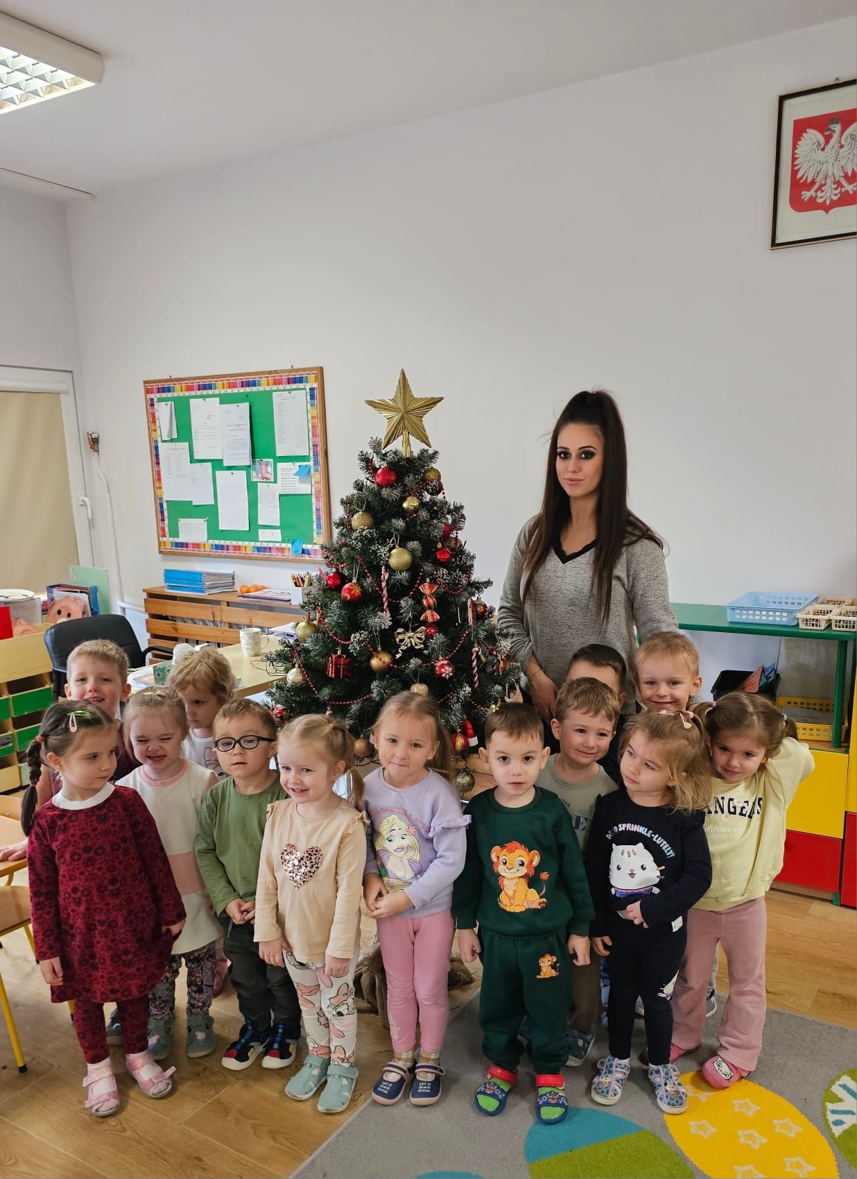 Przedszkolaki na tle ubranej choinki 