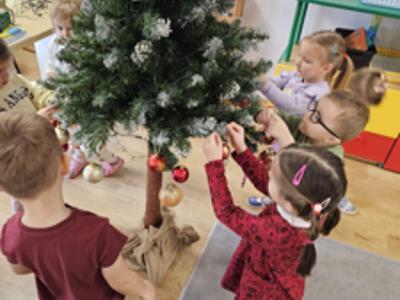 Przedszkolaki ubierające choinkę