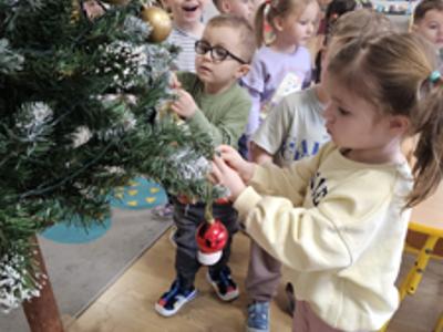 Przedszkolaki ubierające choinkę