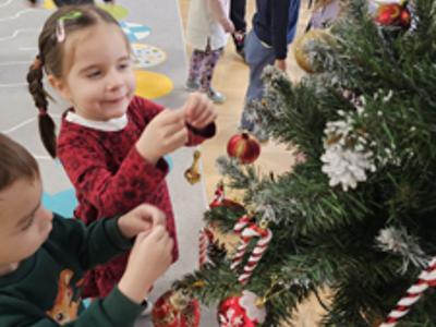 Przedszkolaki ubierające choinkę