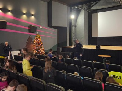 Zdjęcie przedstawia uczestników Ferii z MOK biorących udział w prelekcji policjantów z KPP w Koluszkach na temat bezpiecznego wypoczynku. 