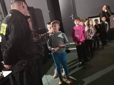 Zdjęcie przedstawia uczestników Ferii z MOK biorących udział w prelekcji strażaków z PSP w Koluszkach na temat bezpiecznego wypoczynku. 