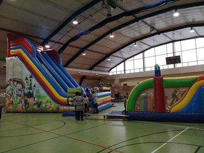 Zdjęcie przedstawia uczestników II turnusu Ferii z MOK 2023 podczas zabawy na dmuchańcach w hali Ośrodka Sportu i Rekreacji w Koluszkach.