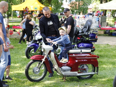 Zdjęcie przedstawia chłopca siedzącego na motocyklu