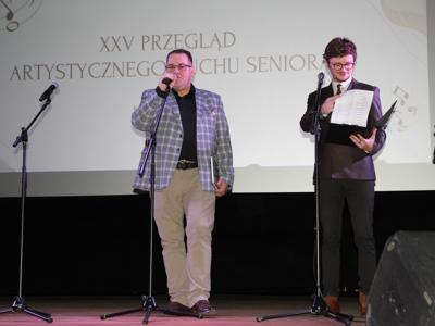 Zdjęcie dyrektora MOK oraz prowadzącego przegląd rozpoczynających uroczystość na scenie
