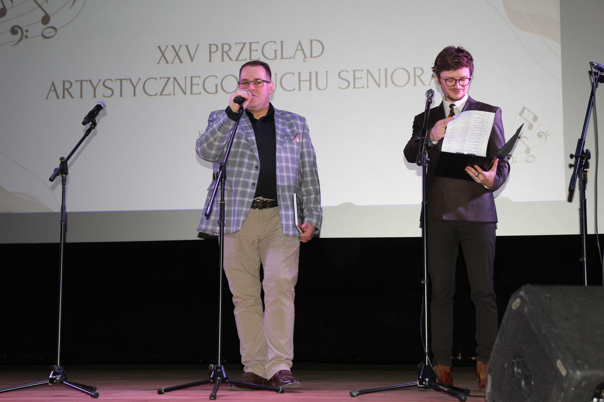 Zdjęcie dyrektora MOK oraz prowadzącego przegląd rozpoczynających uroczystość na scenie