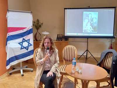 Dina siedząca na krześle i opowiadająca swoją historię