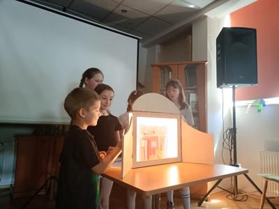 Dzieci przedstawiają teatrzyk kamishibai