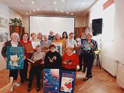 Grupa seniorów pokazująca książki