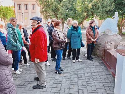 Grupa seniorów wraz z przewodnikiem na wycieczce w Łęczycy