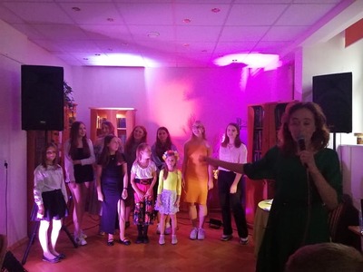 Dzieci wraz ze swoją trenerką muzyczną na scenie
