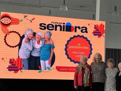 Trzy kobiety przy plakacie informacyjnym forum seniora