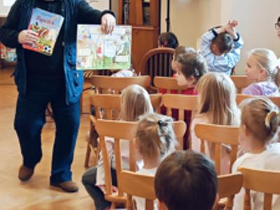 Autor pokazuje dzieciom książkę 