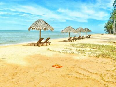 pomarańczowe klapki na plaży, parasole, leżaki - Zdjęcie dodane przez Pixabay: https://www.pexels.com/pl-pl/zdjecie/lezaki-pod-parasolem-w-shoreline-531035/