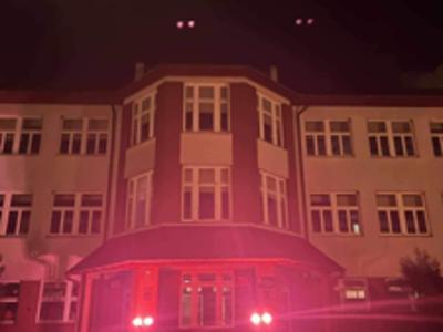 Wejście do Publicznej Szkoły Podstawowej w Jastrzębiu oświetlone czerwonym światłem