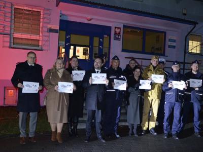 Wejście do Komendy Powiatowej Policji w Szydłowcu oświetlone czerwonym światłem
na zdjęciu również Policjanci, Strażacy, Starosta Szydłowiecki, Wicestarosta Szydłowiecki, Burmistrz Szydłowca, Wiceburmistrz Szydłowca - zdjęcie 3