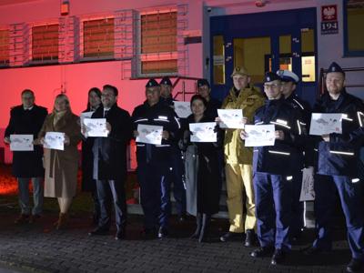 Wejście do Komendy Powiatowej Policji w Szydłowcu oświetlone czerwonym światłem
na zdjęciu również Policjanci, Strażacy, Starosta Szydłowiecki, Wicestarosta Szydłowiecki, Burmistrz Szydłowca, Wiceburmistrz Szydłowca - zdjęcie 4