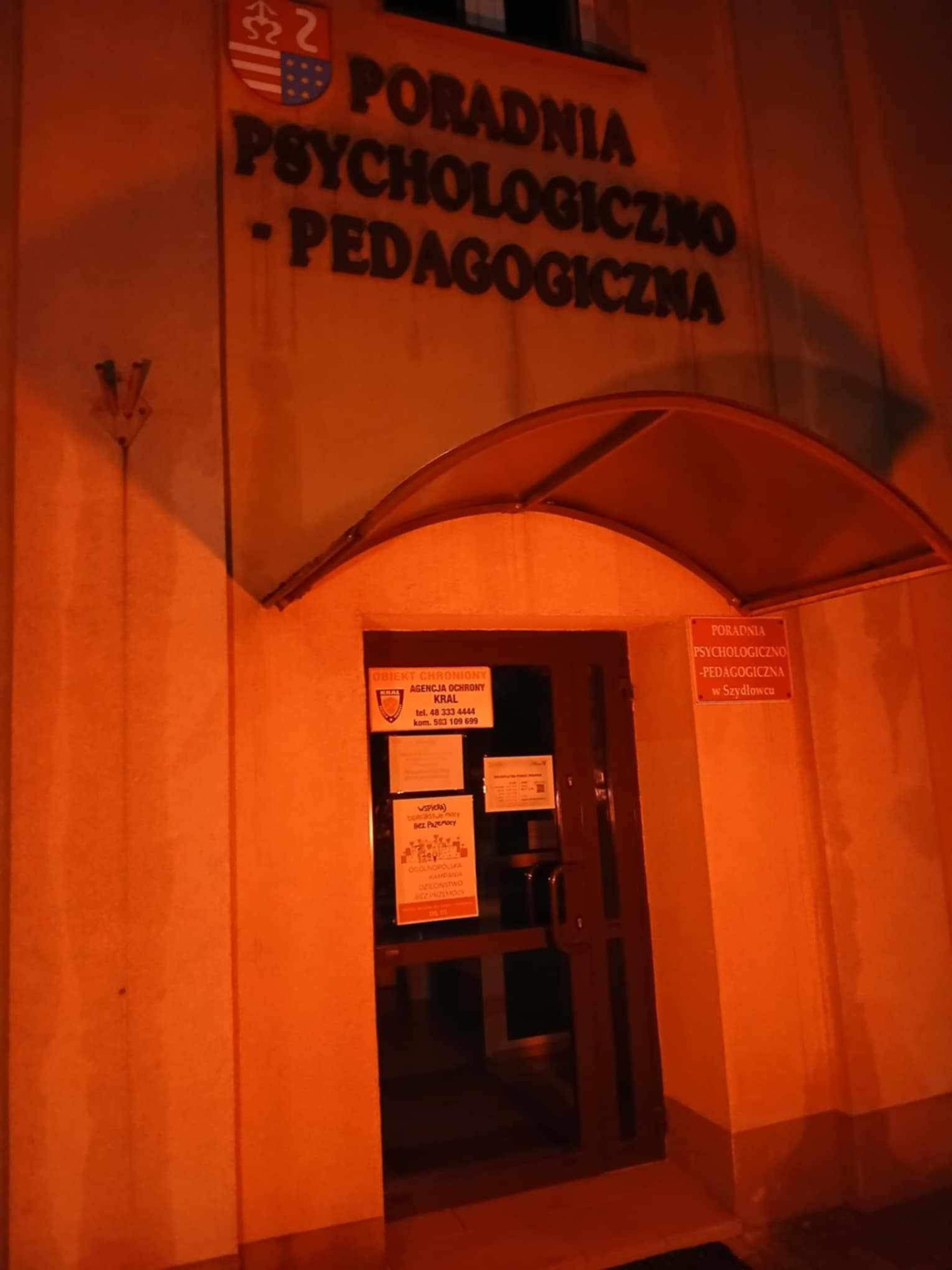 Wejście do Poradni Psychologiczno-Pedagogicznej w Szydłowcu oświetlone czerwonym światłem