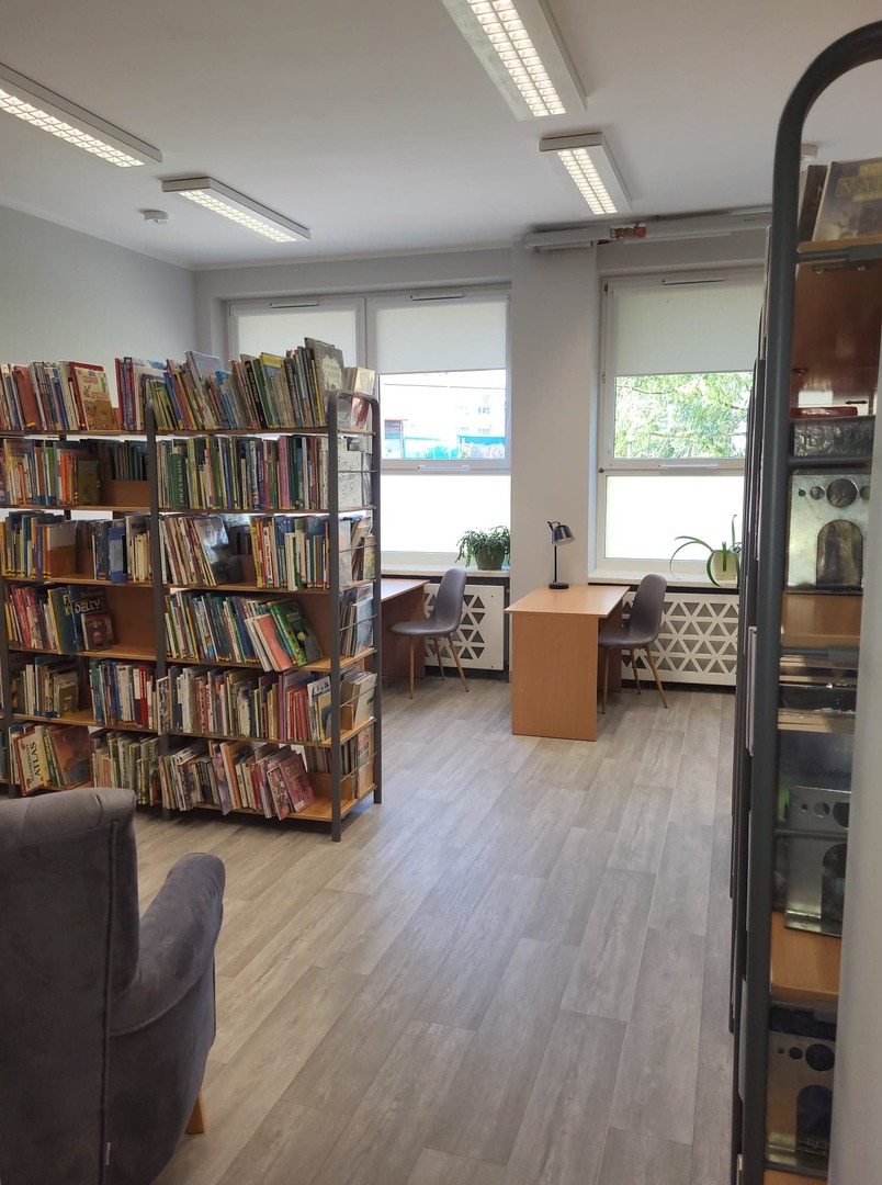 Na zdjęciu znajduje się księgozbiór biblioteki i czytelnia [1488x2000]