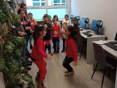 Na zdjęciu znajdują się uczestnicy warsztatów. Dzieci stoją i wykonują zadania.