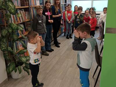 Na zdjęciu znajdują się uczestnicy warsztatów. Dzieci stoją i wykonują zadania.