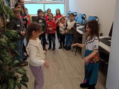Na zdjęciu znajdują się uczestnicy warsztatów. Dzieci stoją i wykonują zadania.