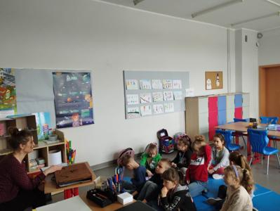 Na zdjęciu znajdują się uczestnicy warsztatów. Dzieci siedzą na materacach. Zdjęcie wykonano w Szkole Podstawowej w Dębnicy.