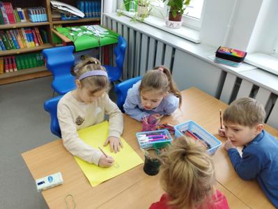 Na zdjęciu znajdują się uczestnicy warsztatów. Dzieci siedzą przy stole i wykonują prace. Zdjęcie wykonano w Szkole Podstawowej w Dębnicy.