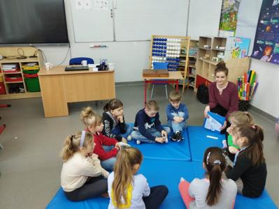 Na zdjęciu znajdują się uczestnicy warsztatów. Dzieci siedzą w kręgu na materacach. Zdjęcie wykonano w Szkole Podstawowej w Dębnicy.