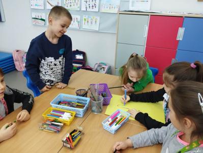 Na zdjęciu znajdują się uczestnicy warsztatów. Dzieci siedzą przy stole i wykonują prace. Zdjęcie wykonano w Szkole Podstawowej w Dębnicy.