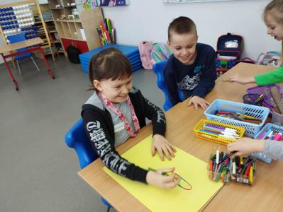 Na zdjęciu znajdują się uczestnicy warsztatów. Dzieci siedzą przy stole i wykonują prace. Zdjęcie wykonano w Szkole Podstawowej w Dębnicy.