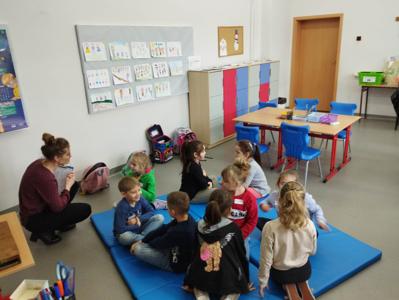Na zdjęciu znajdują się uczestnicy warsztatów. Dzieci siedzą w kręgu na materacach. Zdjęcie wykonano w Szkole Podstawowej w Dębnicy.