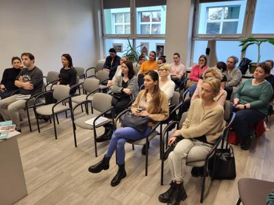Na zdjęciu znajdują się uczestnicy wykładu. Uczestnicy siedzą na krzesłach.