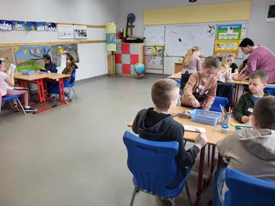 Na zdjęciach znajdują się uczestnicy zajęć. Dzieci siedzą przy stole i wykonują prace plastyczne.
