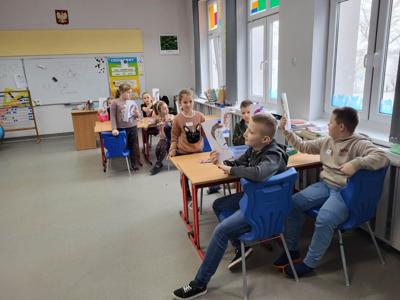 Na zdjęciach znajdują się uczestnicy zajęć. Dzieci siedzą przy stole i wykonują prace plastyczne.