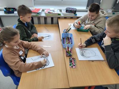 Na zdjęciach znajdują się uczestnicy zajęć. Dzieci siedzą przy stole i wykonują prace plastyczne.