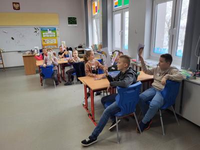 Na zdjęciach znajdują się uczestnicy zajęć. Dzieci siedzą przy stole i wykonują prace plastyczne.