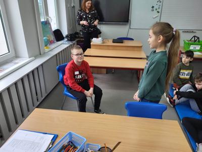 Na zdjęciu znajdują się uczestnicy zajęć. Dzieci wykonują powierzone im zadania.