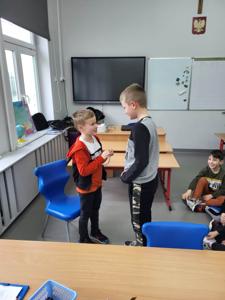 Na zdjęciu znajdują się uczestnicy zajęć. Dzieci wykonują powierzone im zadania.