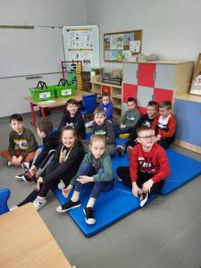Na zdjęciu znajdują się uczestnicy spotkania. Dzieci siedzą na materacach.