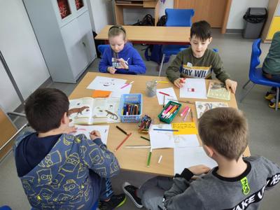 Na zdjęciu znajdują się uczestnicy zajęć. Dzieci wykonują powierzone im zadania.