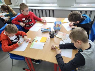 Na zdjęciu znajdują się uczestnicy zajęć. Dzieci wykonują powierzone im zadania.
