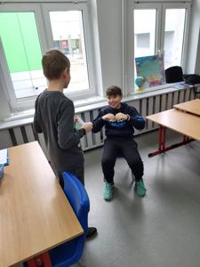 Na zdjęciu znajdują się uczestnicy zajęć. Dzieci wykonują powierzone im zadania.