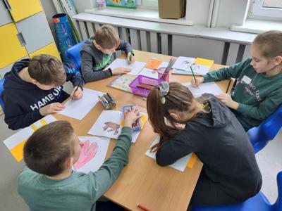 Na zdjęciu znajdują się uczestnicy zajęć. Dzieci wykonują powierzone im zadania.