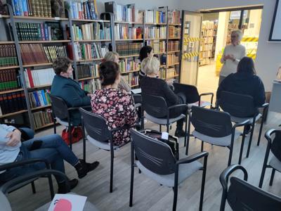 Na zdjęciu znajdują uczestnicy warsztatów. Prowadząca wyświetla prezentacje multimedialną.