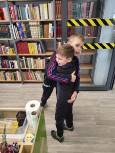 Na zdjęciu znajdują się uczestnicy zajęć. Dzieci wykonują zadania. Zdjęcie wykonano w sali wielofunkcyjnej biblioteki.