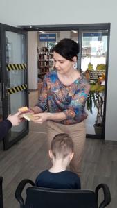 Na zdjęciu znajdują się uczestnicy zajęć. Dzieci siedzą na krzesłach. Zdjęcie wykonano w sali wielofunkcyjnej biblioteki.