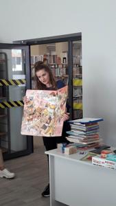 Na zdjęciu znajdują się uczestnicy zajęć. Pani Bibliotekarka trzyma w ręce książkę.
