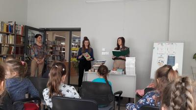 Na zdjęciu znajdują się uczestnicy zajęć. Dzieci siedzą na krzesłach. Zdjęcie wykonano w sali wielofunkcyjnej biblioteki.